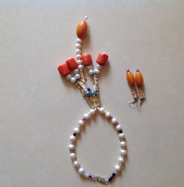 STYLE IS INNATE- necklace designed by Eeefy Pearl is from the luxurious river Benue, river Niger and sea of Lagos, Nigeria Coral is found in Benin, Edo State, Nigeria Bronze is from YOLA, ADAMAWA Amber is found in Bauchi State, Nigeria HEALING PROPERTIES:  Pearls is known for it's calming properties...set to aide purity, charity, integrity, truth and loyalty in its wearer.  Coral prevents ill fortune, protection from skin disease, good for visualization or meditation, symbolizes life and blood force energy.  Pink coral restores harmony to the heart.   Amber aides memory loss, purifies the body, elevates headaches and bone and hart problems.. Known for its stress relieving and calming properties 