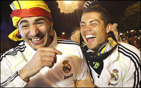 Real Madrid's Benzema and Ronaldo celebrate winning the King's Cup at Cibeles fountain in Madrid...Real Madrid's Karim Benzema (L) and Cristiano Ronaldo laugh as they celebrate winning the King's Cup final soccer match against Barcelona, upon arriving at Cibeles fountain in central Madrid early April 21, 2011. REUTERS/Susana Vera (SPAIN - Tags: SPORT SOCCER)