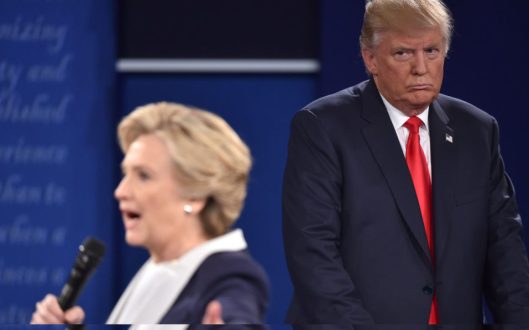 (FILES) This file photo taken on October 9, 2016 shows Republican presidential candidate Donald Trump as he listens to Democratic presidential candidate Hillary Clinton during the second presidential debate at Washington University in St. Louis, Missouri.
Hillary Clinton has accused her Republican presidential rival Donald Trump of "stalking" her during their televised debate on October 9, 2016. Trump often stood closely behind the Democratic nominee glowering as she answered questions from the audience during the town hall-style event in St. Louis. Speaking during an interview on NBC's The Ellen DeGeneres Show set to air October 14, 2016, Clinton said his movements made her feel "really weird" on stage.
/ AFP PHOTO / Paul J. Richards
